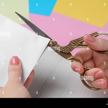 Scissors cutting through a sheet of paper.