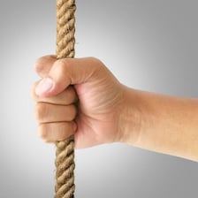 A person firmly grabbing onto a rope