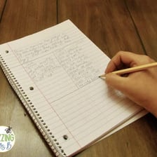 A student writing an essay in a notebook.