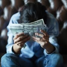 A person counting cash beside a bill that still needs to be paid.