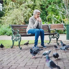 A person sitting inactive while waiting on a bench.