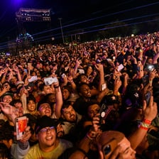 A dense concert crowd moving energetically in a mosh pit.