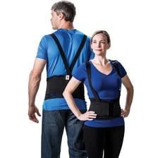 A standing person wearing supportive shoes and a lumbar support belt.