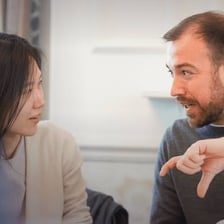 A person raising a hand to object during a discussion