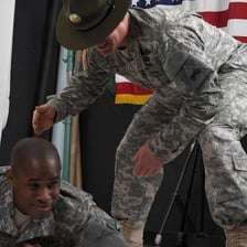 A sergeant instructing a private during military training