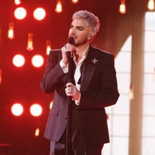 Adam Lambert performing onstage with a microphone