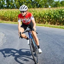 A cyclist pedaling a bicycle at speed.