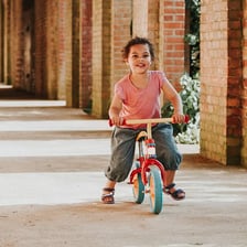 Child riding a bicycle with pedals after using a balance bike