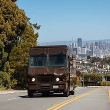 A UPS delivery truck beside a package.