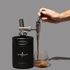 Nitro cold brew coffee being poured from a tap.