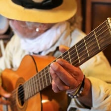 A musician listening attentively to a musical performance.