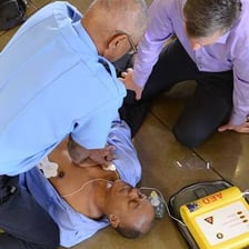 An emergency medical technician demonstrating an automated external defibrillator.