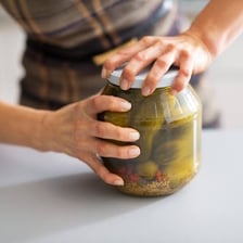 A jar being closed securely with a tight-fitting lid.