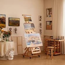 Several easels holding canvases in an art studio.