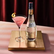 A bottle of triple sec beside a cocktail