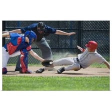 A baseball player sliding toward home plate