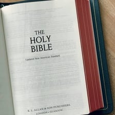 An open Bible resting on a table.