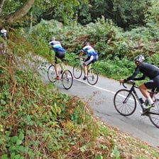 A cyclist pedaling up a steep hill