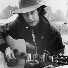 Arlo Guthrie performing with an acoustic guitar.