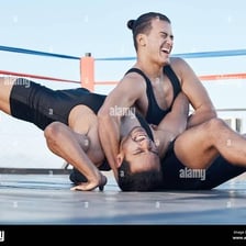 Two wrestlers competing on a wrestling mat.