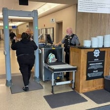 A person being escorted out of an office by security personnel