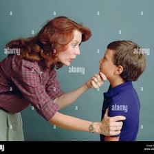 An adult reprimanding a child in a serious conversation