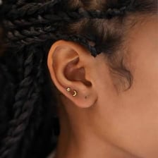 A small stud earring worn on an earlobe.