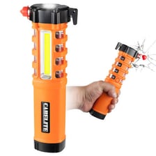 A flashlight next to supplies in an emergency kit.