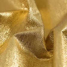 A close-up of shiny gold lamé fabric
