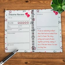A reviewer taking notes during a live theater performance