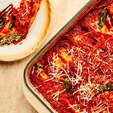 Manicotti pasta covered with red tomato sauce.