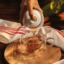 A cup of tea with hot water steeping the leaves.