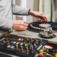 A disc jockey working at a pair of turntables