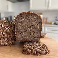 A sliced loaf of rye bread covered with seeds