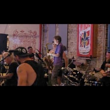 A ska band performing onstage with horn players