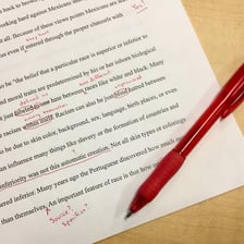 Person marking and correcting details in written text.