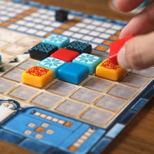 Decorative game tiles are arranged on a tabletop beside mahjong tiles.