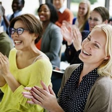 An audience applauding someone being praised at a ceremony.