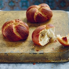 A crusty Kaiser roll with a patterned top.