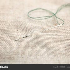 A needle and thread sewing stitches into fabric