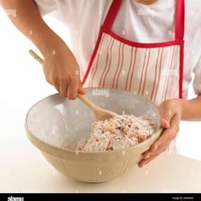 A spoon stirring ingredients together in a bowl.