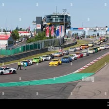 A race car at the front of a starting grid in pole position.