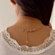 A necklace clasp resting at the back of a person’s neck