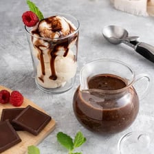 Chocolate fudge sauce drizzled over an ice-cream sundae.