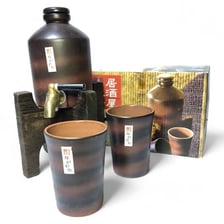 An izakaya-style display of sake bottles and serving cups.