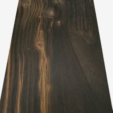 A close view of dark ebony wood with visible grain.
