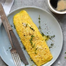 An egg beside ingredients used to make an omelet