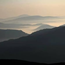 A mountain range appears far away across an open landscape.