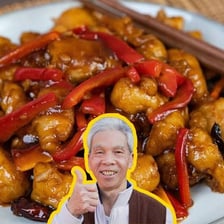 A plate of General Tso’s chicken with sauce and garnish.