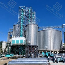 A tall grain silo standing apart from other farm buildings